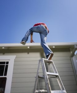 Man climbing onto roof from ladder